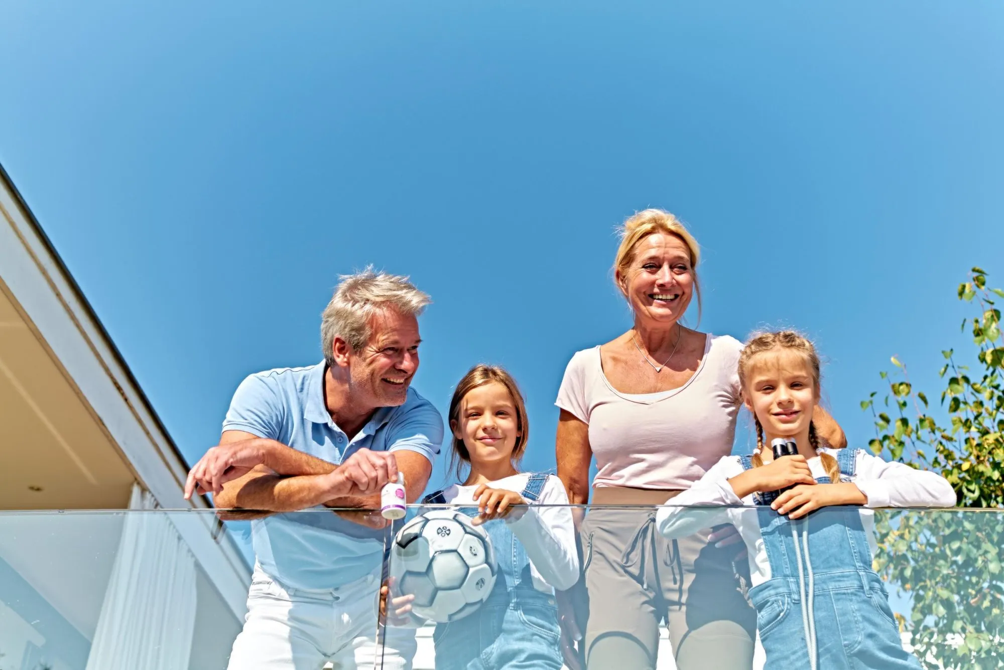 Familie mit zwei Kindern lacht auf der Terrasse